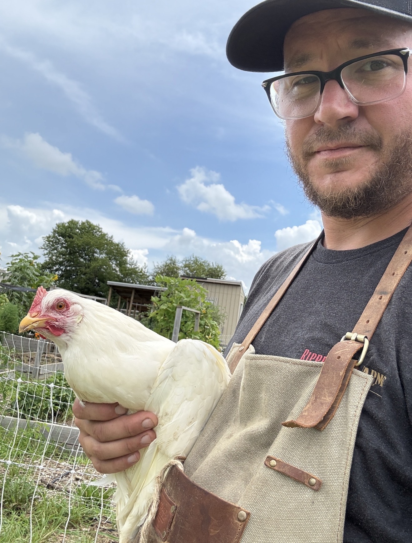 Aaron Singerman holding a pasture-raised chicken at Ripple Run Farms